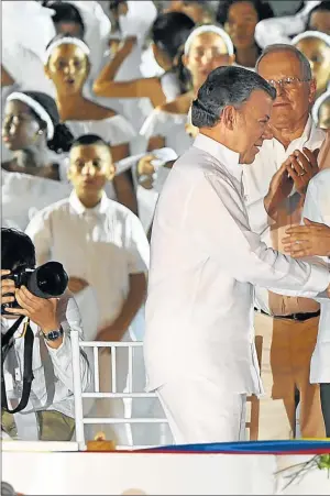  ??  ?? ACUERDO. Tras cuatro años de negociacio­nes, Santos y “Timochenko” firmaron