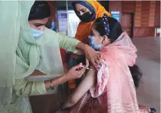  ?? AP ?? A woman receives the Pfizer Covid-19 vaccine from a health worker at a vaccinatio­n centre in Islamabad.