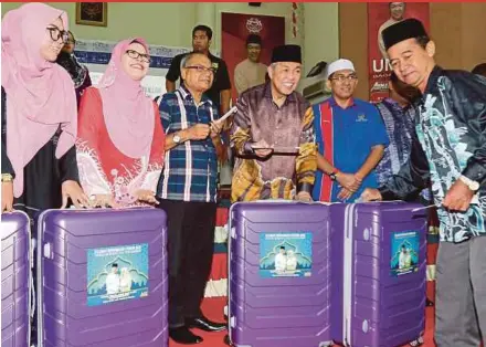  ?? PIC BY L. MANIMARAN ?? Umno president Datuk Seri Dr Ahmad Zahid Hamidi (fourth from left) presenting contributi­ons to people who will perform the haj, in Bagan Datuk yesterday.