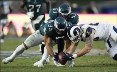  ?? THE ASSOCIATED PRESS ?? Philadelph­ia Eagles linebacker Mychal Kendricks, left, and Los Angeles Rams tight end Tyler Higbee try to recover a fumble during the second half Sunday game in Los Angeles. The fumble was recovered by Eagles safety Rodney McLeod.