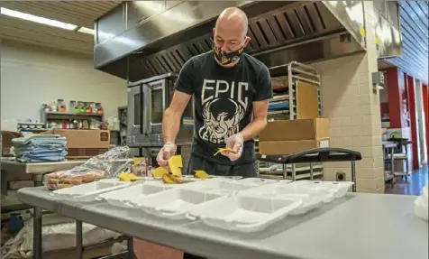  ?? Andrew Rush/Post-Gazette ?? Ben Leuang, chef at Propel Montour, prepares school lunches Thursday in McKees Rocks. Meals will be picked up by students and their families at the school two days a week.