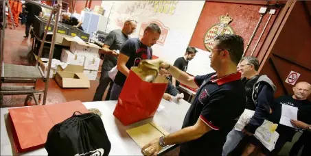  ?? (Photos Cyril Dodergny) ?? Dans ces sacs en papier rouge : l’équipement qui leur permettra de prêter main forte bénévoleme­nt sur le circuit du Grand Prix de Monaco.