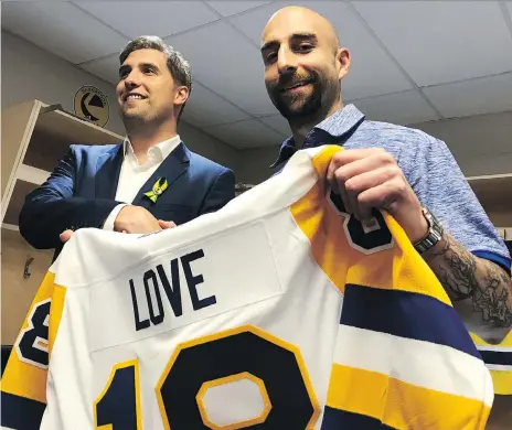  ?? JEFF LOSIE ?? Saskatoon Blades general manager Colin Priestner, left, presents a jersey to the team’s new head coach Mitch Love on Wednesday at SaskTel Centre in Saskatoon. Love, whose Everett Silvertips advanced to this year’s WHL final, joins a franchise that...