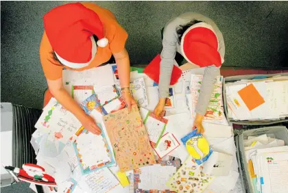  ?? Photo / Brett Phibbs ?? Santa’s helpers — NZ Post staff Rosalie Hinton and Cynthia Lam sort out the letters from children addressed to Santa at the Auckland City Mail Centre.