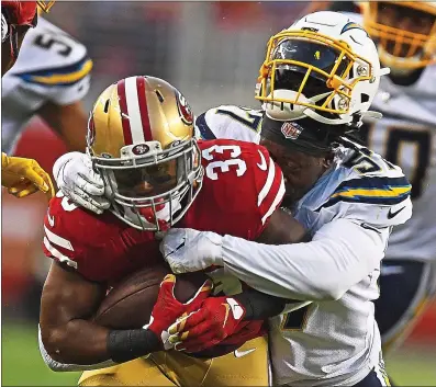  ?? JOSE CARLOS FAJARDO — STAFF PHOTOGRAPH­ER ?? The 49ers’ Austin Walter, left, plows through Jatavis Brown and the Chargers defense during Thursday night’s preseason finale.