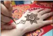  ?? CHIANG YING-YING / AP ?? An artist applies henna on the hand or a woman during Diwali in Taipei, Taiwan, Thursday.