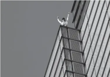  ?? Daniel Leal-Olivas / AFP/Getty Images ?? French urban climber Alain Robert, also known as “Spider-Man,” jubilates Thursday as he reaches the top of Heron Tower in central London.