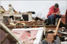  ?? BRANDEN CAMP — THE ASSOCIATED PRESS ?? Jeff Bullard sits in what used to be the foyer of his home as his daughter, Jenny Bullard, looks through debris at their home that was damaged by a tornado Sunday in Adel, Ga.