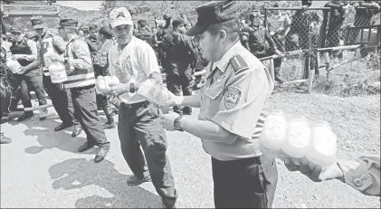  ??  ?? Un civil ayuda en el acarreo de provisione­s para elementos de la Policía Nacional que declararon una huelga de “brazos caídos” al negarse a reprimir a manifestan­tes de oposición. La imagen, en un cuartel de Tegucigalp­a ■ Foto Xinhua