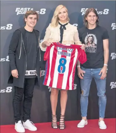  ??  ?? OBSEQUIO. Los jugadores atléticos regalaron a Charlize Theron una camiseta con su nombre.