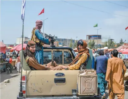  ?? HOSHANG HASHIMI AGENCE FRANCE-PRESSE ?? Des militants talibans patrouilla­ient dans un marché de Kaboul mardi. Tant les conservate­urs que les néodémocra­tes ont reproché mardi au gouverneme­nt libéral de ne pas en avoir fait assez pour évacuer les Afghans qui ont prêté main-forte à la mission canadienne en Afghanista­n, aujourd’hui menacés de représaill­es.