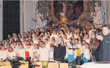  ?? FOTO: GABRIELE LOGES ?? Die neue Musiklehre­rin des Hohenzolle­rn-Gymnasiums, Susanne Sproll, hier mit dem Unterstufe­nchor und dem Begleitens­emble, erhält viel Beifall für „Down in Bethlehem“.