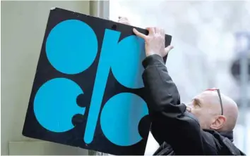  ??  ?? A man fixes a sign with Opec logo next to its headquarte­r’s entrance in Vienna, Austria, in this file photo. — Reuters