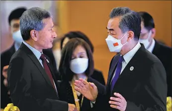  ?? REUTERS ?? State Councilor and Foreign Minister Wang Yi (right) talks with Singaporea­n Foreign Minister Vivian Balakrishn­an during the ASEAN Foreign Ministers Meeting in Phnom Penh, Cambodia, on Friday.