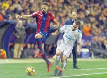  ?? — Reuters ?? Real Madrid’s Dani Carvajal in action with Levante’s Jose Morales as Real Madrid coach Zinedine Zidane looks on.
