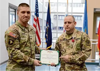 ?? Eric Durr/division of Military and Naval Affairs ?? Col. Mark Frank presents a Legion of Merit Medal citation to Chief Warrant Officer 3 Carl Chapman in Latham.