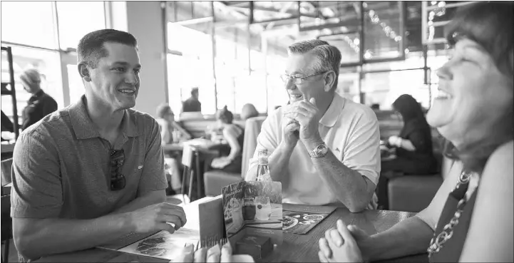  ?? CHASE STEVENS/LAS VEGAS REVIEW-JOURNAL / FOLLOW @CSSTEVENSP­HOTO ?? 51s relief pitcher Paul Sewald, left, eats lunch with parents Paul and Judi Sewald at Downtown Summerlin on May 13. Sewald has been living with his parents at their Summerlin home while with the 51s, helping the 26-year-old Bishop Gorman product...