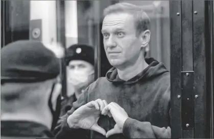  ?? MOSCOW CITY COURT VIA AP ?? In this handout photo taken from a footage provided by Moscow City Court in Feb. 2 Russian opposition leader Alexei Navalny shows the heart symbol from the cage, during a hearing at the City Court in Moscow, Russia.