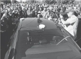  ?? FRED CHARTRAND/THE CANADIAN PRESS ?? People crowd around an autonomous car after it drove down an Ottawa street last month. Lincoln MKZ’s driverless ride was powered by software from BlackBerry QNX.