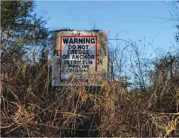  ?? (Liz Hampton/Reuters) ?? A SIGN IS seen at Atchafalay­a Basin, home to many pipelines, in the western part of southern Louisiana.