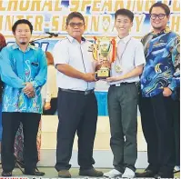  ??  ?? TAHNIAH: Galau menyampaik­an piala kemenangan kepada konduktor SMK Chung Hua Miri Michael Jun Ze Kong selepas diumumkan sebagai juara Pertanding­an Choral Speaking Antara Sekolah-Sekolah Menengah Bahagian Miri di Miri.