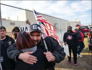  ?? The Associated Press ?? CONTRACT APPROVED: Flint Assembly Electricia­n Mike Perez celebrates with others outside of Flint Engine South after UAW ratified their contract with General Motors marking the end of the strike on Friday.