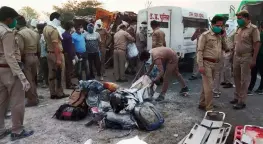  ?? — PTI ?? Police officials inspect the spot where atleast 25 migrants were killed and 40 injured after a trailer truck carrying labourers collided with a DCM van at Mihauli in Auraiya district of UP on Saturday.