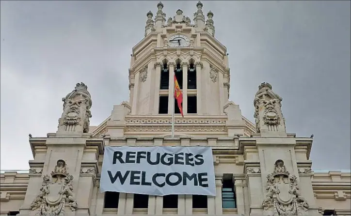  ?? JUANJO MARTÍN / EFE ?? Bienvenida de Madrid. Una pancarta colgada en la fachada de la sede del Ayuntamien­to de Madrid saluda a los refugiados