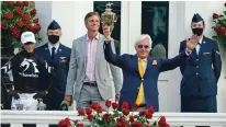  ?? JEFF ROBERSON/ASSOCIATED PRESS ?? Trainer Bob Baffert holds the trophy Saturday after John Velazquez, left, rode Authentic to victory in the Kentucky Derby at Churchill Downs in Louisville, Ky.