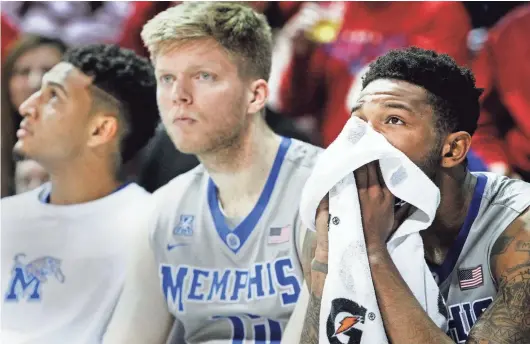  ?? MARK WEBER/THE COMMERCIAL APPEAL ?? Dejected University of Memphis guard Markel Crawford (right) watches from the bench with teammates Christian Kessee (let) and Chad Rykhoek (middle) during a 103-62 drubbing by No. 19 Southern Methodist at Moody Coliseum in Dallas. At one point in the...