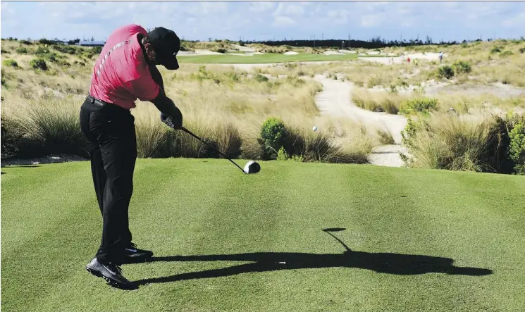  ?? DANTE CARRER/THE ASSOCIATED PRESS/FILE ?? Tiger Woods tees off on the 14th hole during the Hero World Challenge in Nassau, Bahamas, last month. Woods says he is golfing without pain.