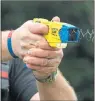  ??  ?? SHOCK: A police officer shows how a Taser would look in action.