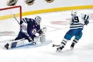  ?? Fred Greenslade/Associated Press ?? The Sharks’ Logan Couture nets the game-winning goal past Winnipeg Jets goaltender David Rittich.