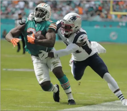  ?? LYNNE SLADKY - THE ASSOCIATED PRESS ?? FILE - In this Sunday, Dec. 9, 2018file photo, New England Patriots strong safety Duron Harmon (21) tackles Miami Dolphins running back Frank Gore (21), during the first half of an NFL football game in Miami Gardens, Fla.