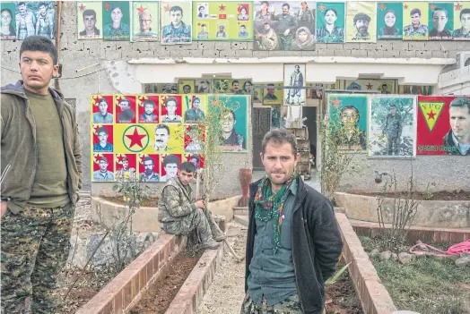  ??  ?? POSTER CHILDREN: Fighters with the People’s Protection Units, or YPG, a mainly-Kurdish militia in Syria, in a space dedicated to war dead in Kobane.