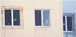  ?? AMY BETH BENNETT South Florida Sun Sentinel ?? A sign reading ’1240 west facing window’ and five bullet holes can be seen in a third-floor window of the 1200 building at Marjory Stoneman Douglas High School.