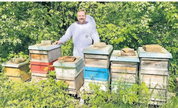  ?? FOTO: SARAH KOHN ?? Rene Bamberg, Hobby-Imker und Vorsitzend­er des Imkerverei­ns Jüchen, zeigt einen Teil seiner Bienenstöc­ke am Naturlehrp­fad.