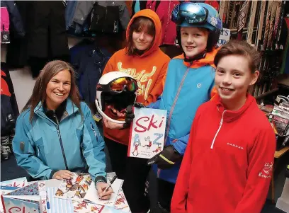  ?? ?? ●●Skier and author Kimberley Kay signs copies of her book Ski A to Z with members of the Saturday Morning Developmen­t Club, from left, Jess Greenwood, 13, Alexander Ashdown, 13, and Issy Slater, 12.