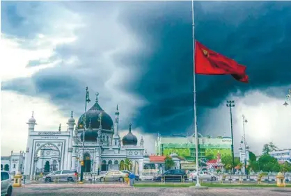  ??  ?? The skies over Masjid Zahir Alor Star in Kedah yesterday seem to reflect the nation's gloom as the state flag is seen flying at half-mast.