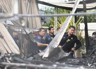  ??  ?? Firefighte­rs view the scene of the fire at the Golden Wheel Mobile Home Park. The park near Coyote Creek was ravaged by flooding in San Jose only a few months ago.