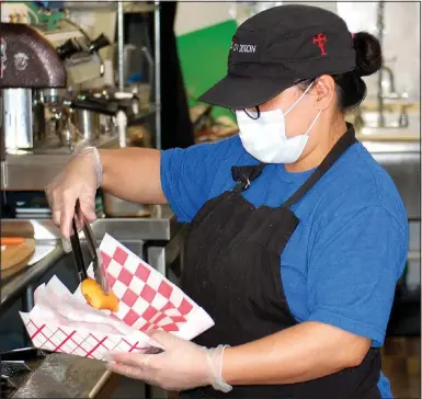  ?? Photos by Janelle Jessen/Herald-Leader ?? Jasmine Allgood, owner of Tintos & Tapas in downtown Siloam Springs, plates some empanadas.