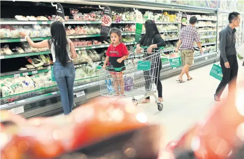  ?? PATIPAT JANTHONG ?? Shoppers select produce at a hypermarke­t. Consumer confidence improved in March, particular­ly for durable goods such as houses.