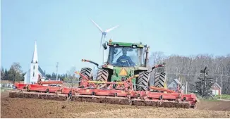  ?? ERIC MCCARTHY ?? Charley McCarthy guides a set of harrows through a field being prepared for potato planting.