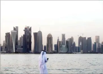  ?? STRINGER/AFP ?? A man looks at his phone on the corniche in the Qatari capital Doha on Sunday.