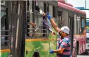  ?? — PTI ?? Volunteers of Sikh community distribute cold drinks among passengers sitting in a DTC bus during a hot summer day in New Delhi on Tuesday.