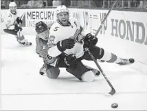  ?? Mark J. Terrill Associated Press ?? A CHASE for the puck results in a double downer for Florida’s Aaron Ekblad, foreground, and the Ducks’ Ondrej Kase.