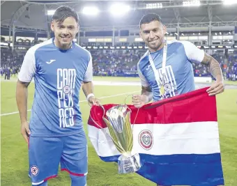  ?? ?? Ángel Romero y Juan Escobar, con el trofeo de la Supercopa de México y la bandera paraguaya.