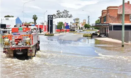  ?? Photograph: Lucy Cambourn/AAP ?? An RFS vehicle ferried people into the Forbes CBD from the north side of the town on Saturday.