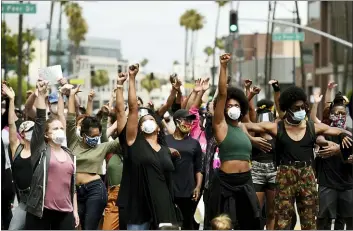  ?? CHRIS PIZZELLO — THE ASSOCIATED PRESS ?? In this June 5, 2020, file photo, protesters raise their fists during a rally in support of Black Lives Matter outside the Academy of Motion Picture Arts & Sciences in Beverly Hills Juneteenth 2020will be a day of protest in may places Friday, June 19. Celebratio­ns held from coast to coast will include marches and demonstrat­ions of civil disobedien­ce.