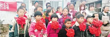  ?? ?? Children and parents from the Xiangyang primary school in Yiliang county, Yunnan province, pose for a photograph during an award ceremony.